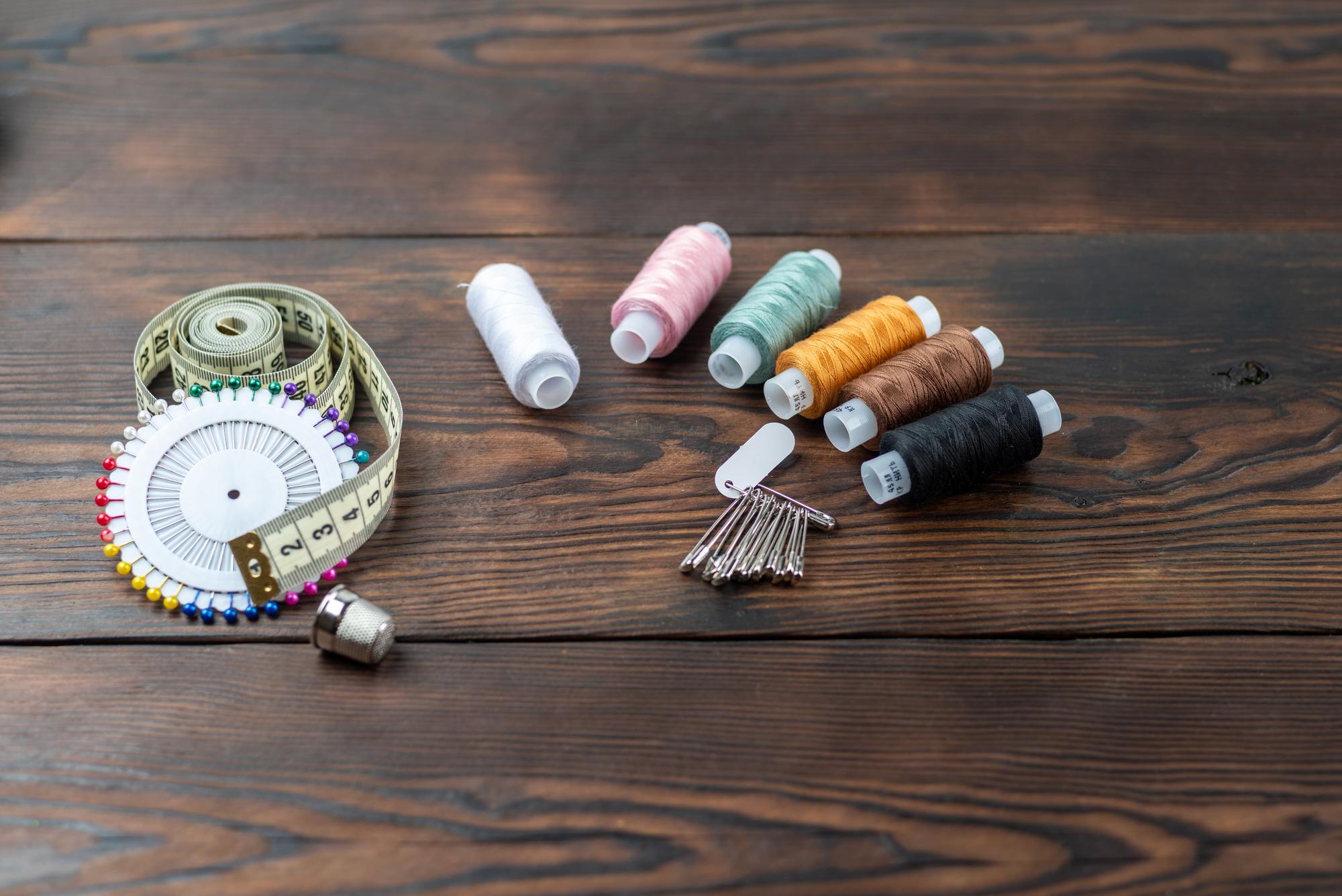 studio table with thread spools and embroidered sample